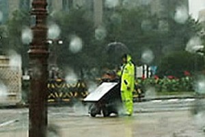 cop holding an umbrella for a disabled protester