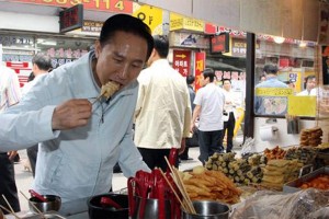 Former President Lee Myung-bak is eating food at a street stall.